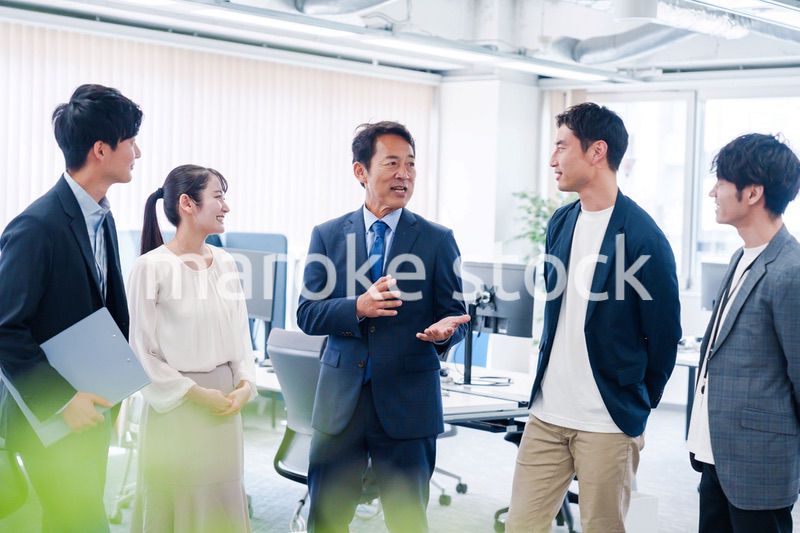 オフィスで立ち話をするビジネスパーソン