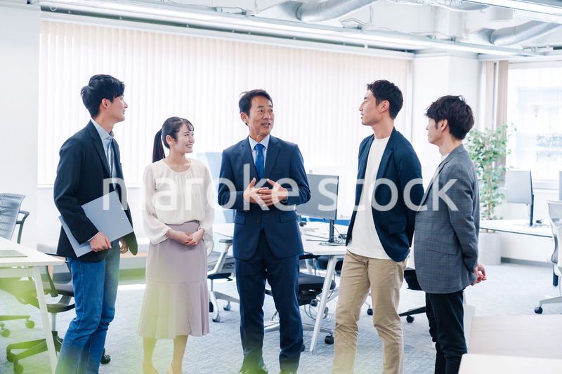 オフィスで立ち話をするビジネスパーソン