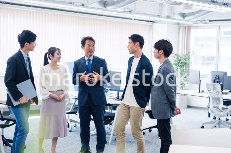 オフィスで立ち話をするビジネスパーソン