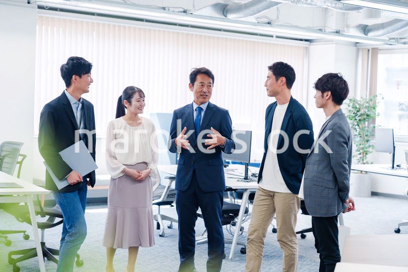 オフィスで立ち話をするビジネスパーソン