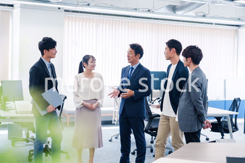 オフィスで立ち話をするビジネスパーソン