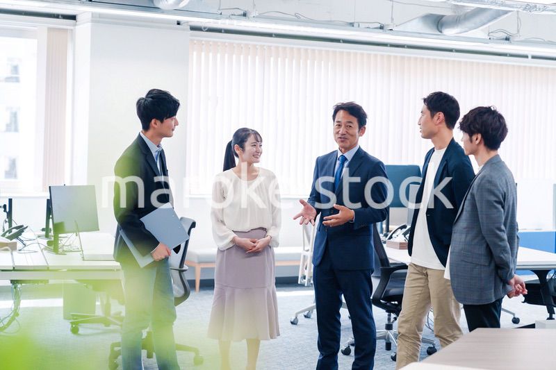 オフィスで立ち話をするビジネスパーソン