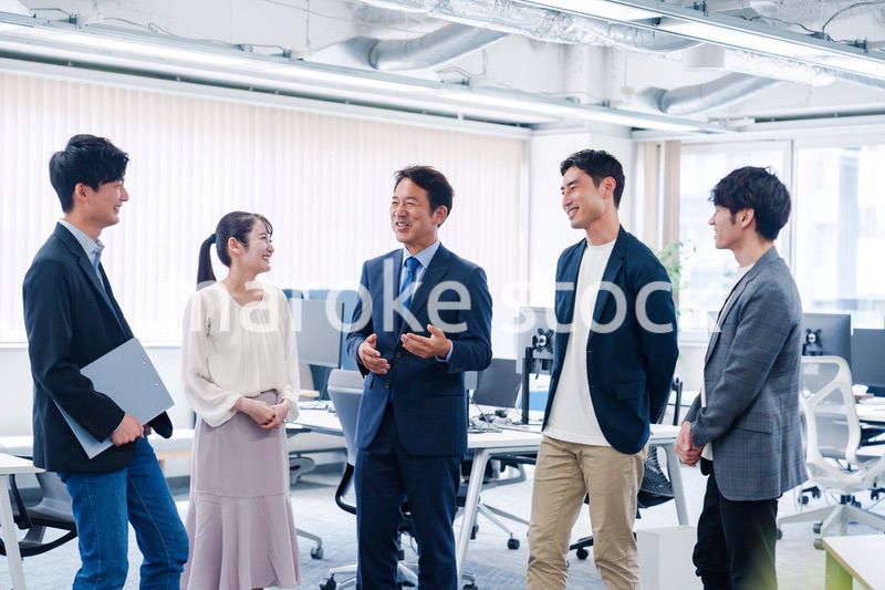 オフィスで立ち話をするビジネスパーソン