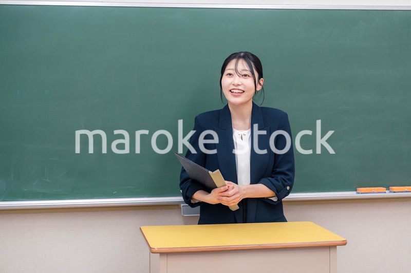 学校で教壇に立って授業をする若い女性教師
