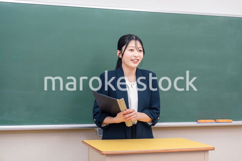 学校で教壇に立って授業をする若い女性教師