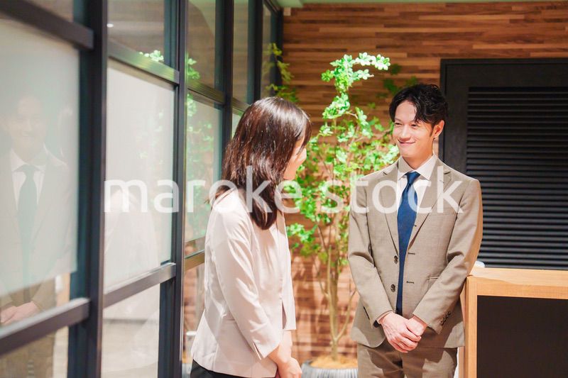 オフィスにお客様を通す女性の秘書