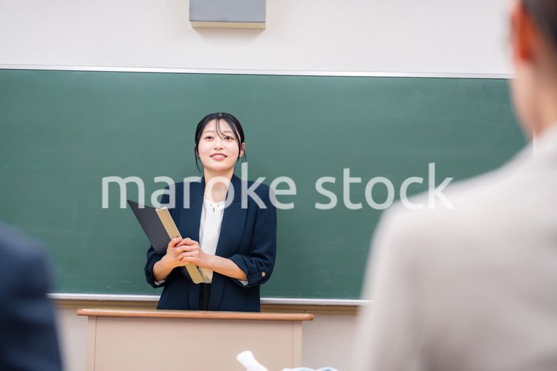 学校で教壇に立って授業をする若い女性教師