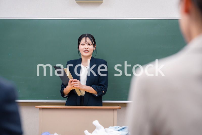学校で教壇に立って授業をする若い女性教師