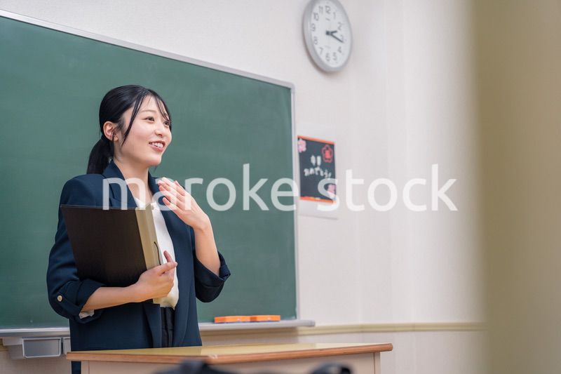 学校で教壇に立って授業をする若い女性教師