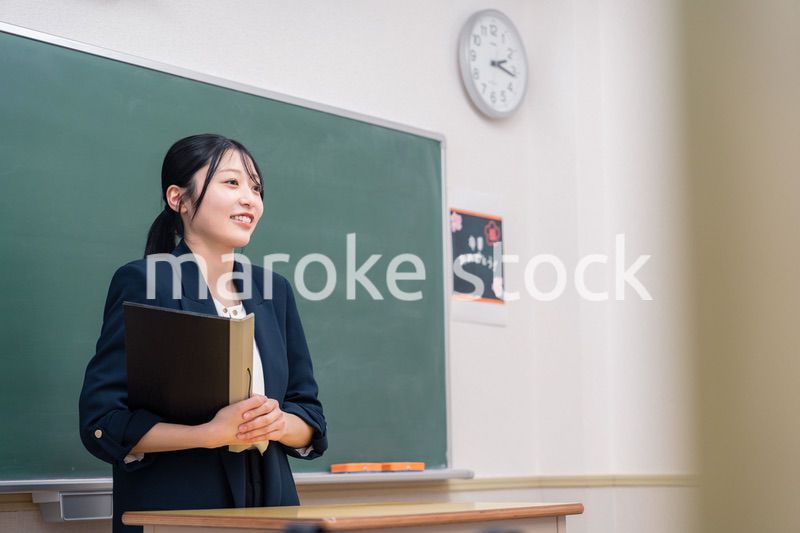 学校で教壇に立って授業をする若い女性教師