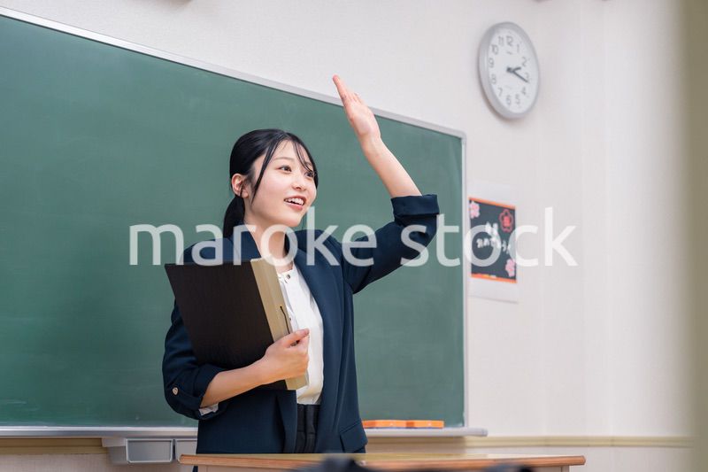 学校で教壇に立って授業をする若い女性教師