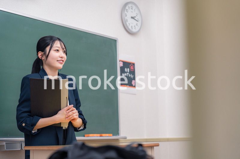 学校で教壇に立って授業をする若い女性教師