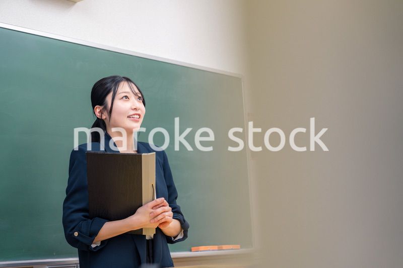 学校で教壇に立って授業をする若い女性教師