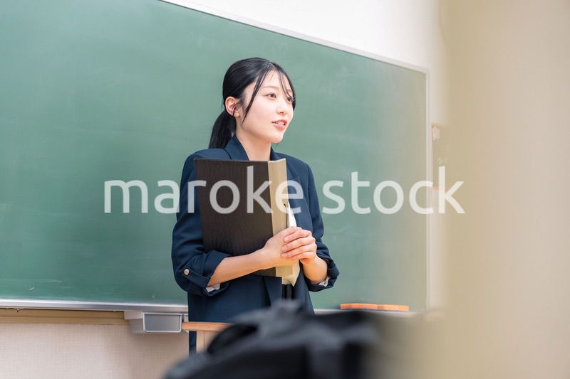学校で教壇に立って授業をする若い女性教師