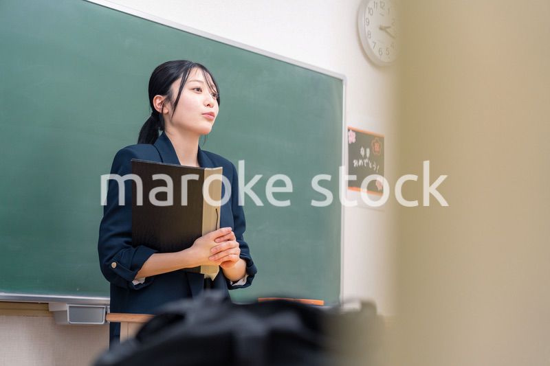 学校で教壇に立って授業をする若い女性教師