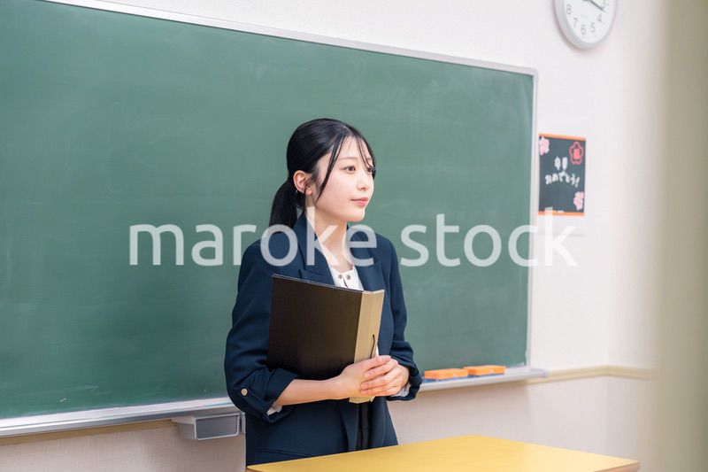 学校で教壇に立って授業をする若い女性教師