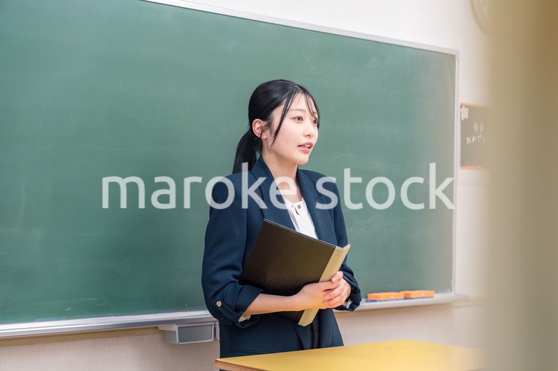 学校で教壇に立って授業をする若い女性教師