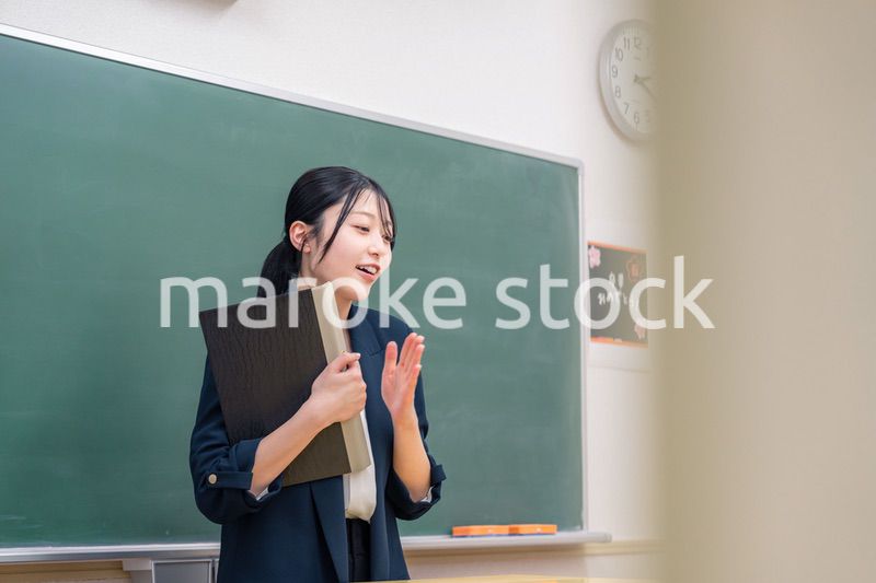 学校で教壇に立って授業をする若い女性教師