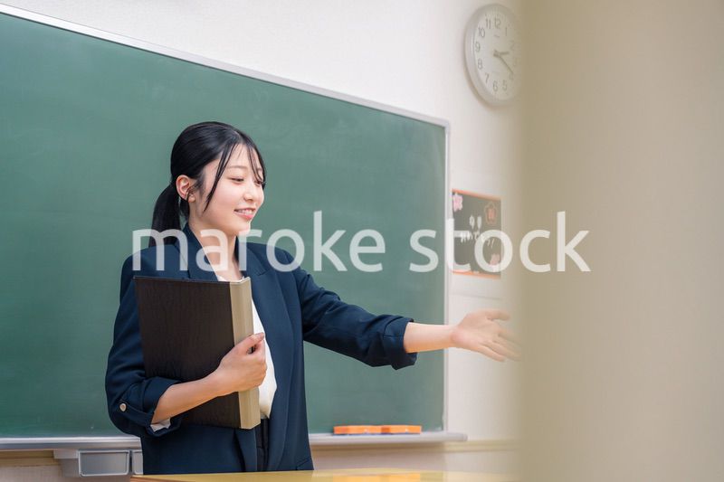 学校で教壇に立って授業をする若い女性教師