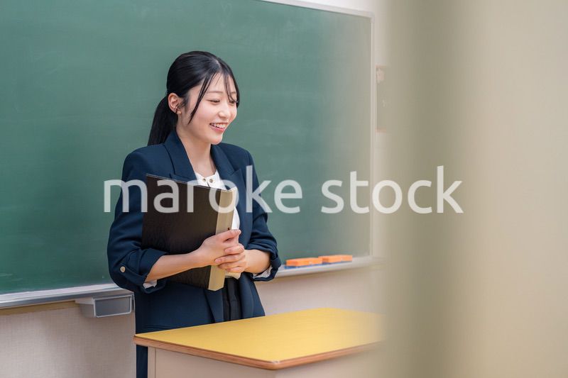 学校で教壇に立って授業をする若い女性教師