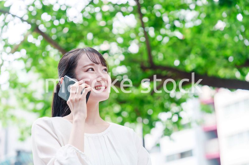 外で通話をする若い女性