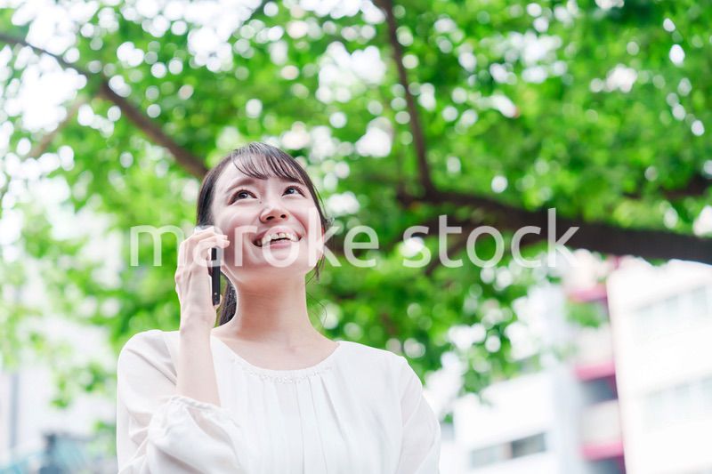 外で通話をする若い女性