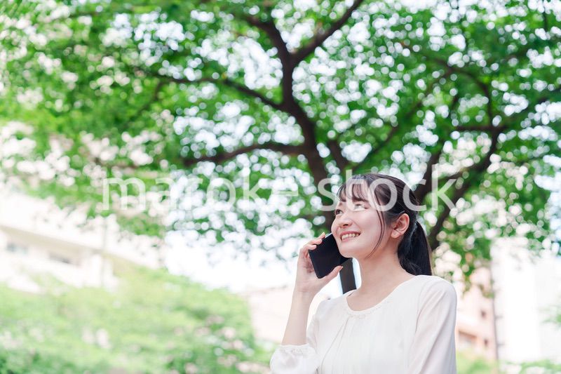 外で通話をする若い女性