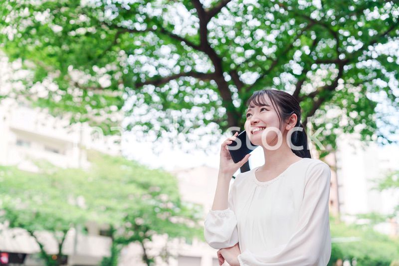 外で通話をする若い女性