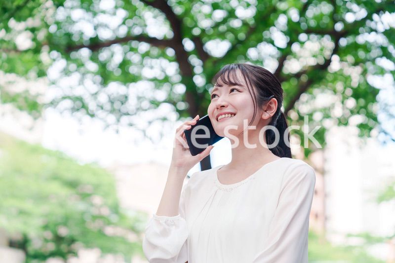 外で通話をする若い女性