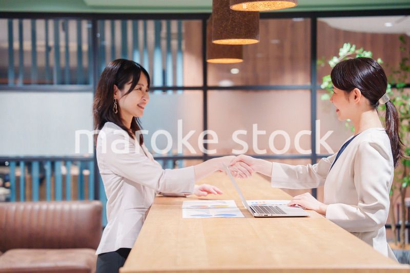 笑顔で握手をする女性のビジネスパーソン