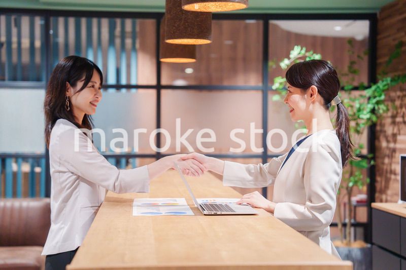 笑顔で握手をする女性のビジネスパーソン