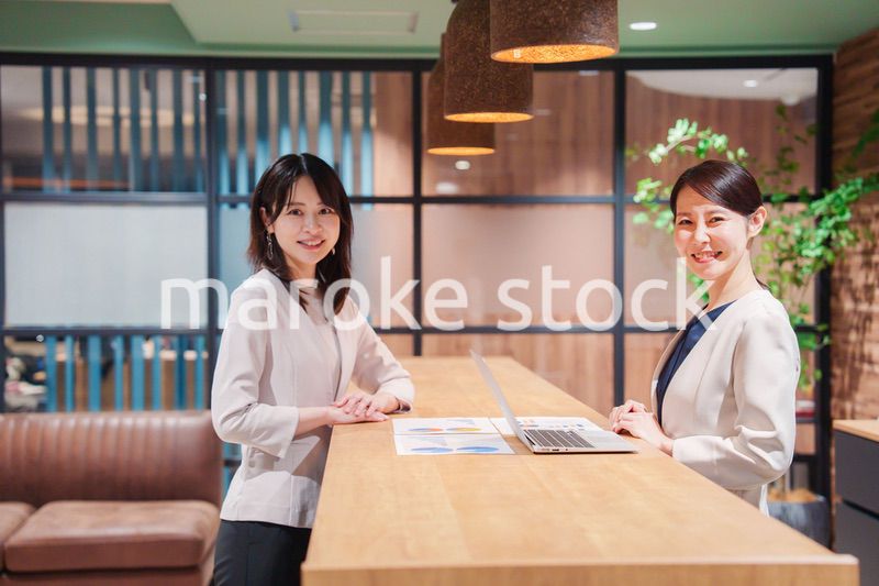 カメラ目線で笑顔の2人の働く女性