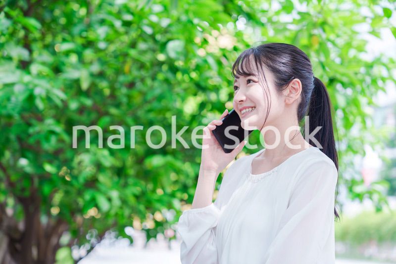 外で通話をする若い女性