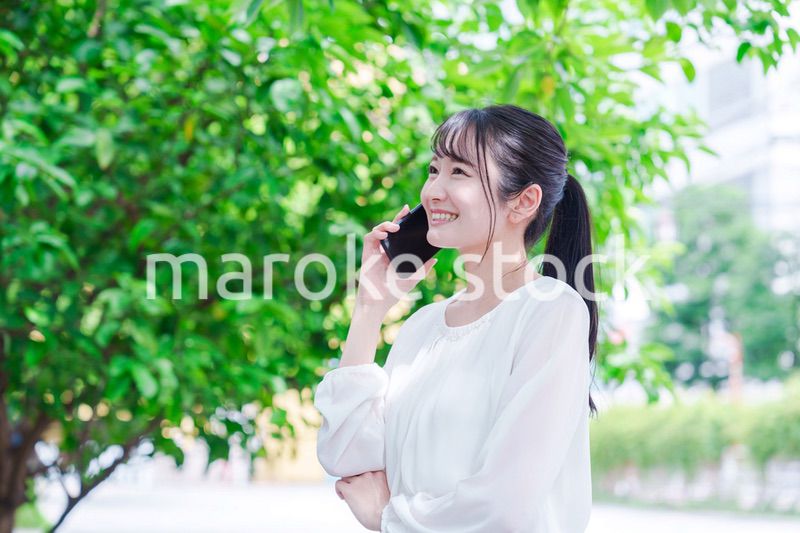 外で通話をする若い女性