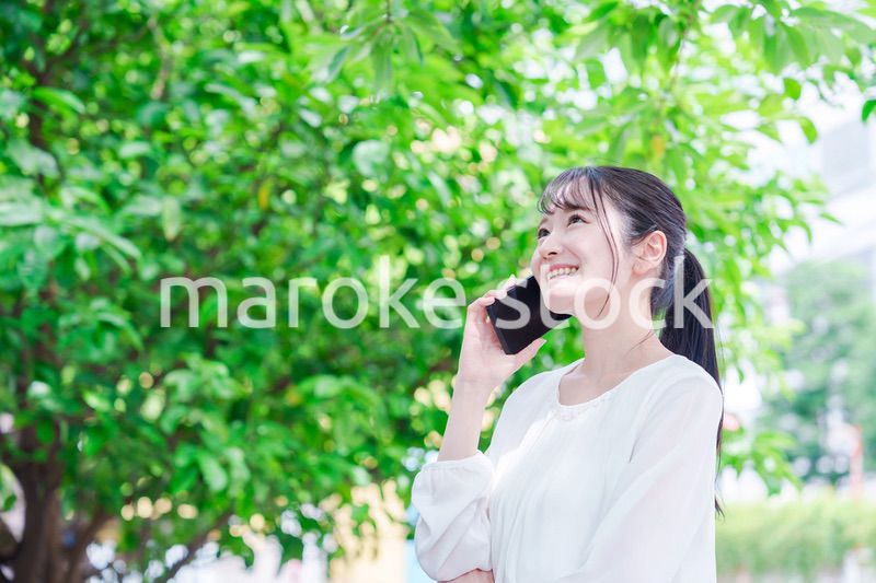 外で通話をする若い女性