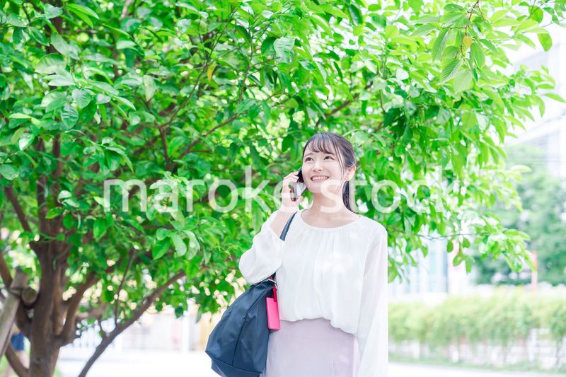 外で通話をする若い女性