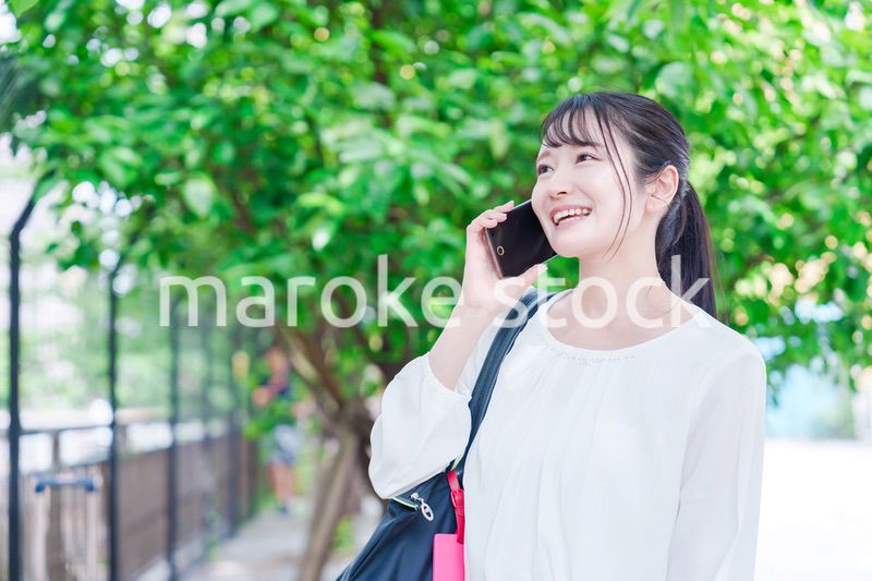 外で通話をする若い女性