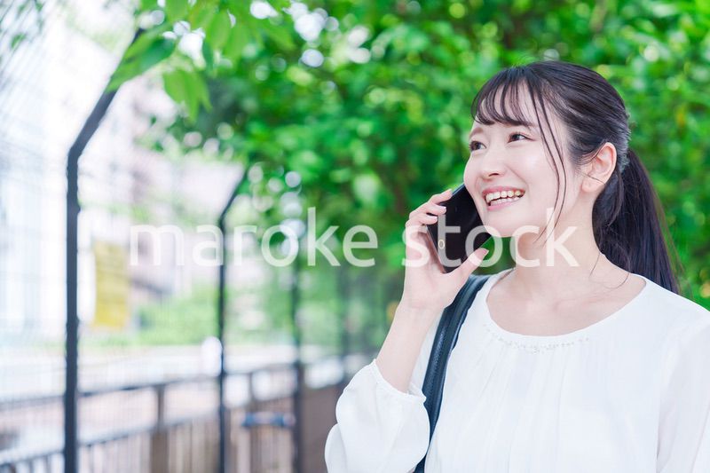 外で通話をする若い女性