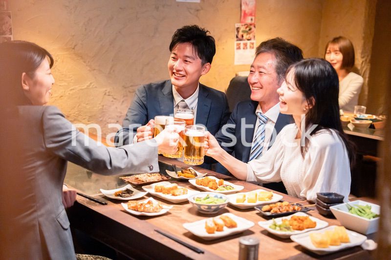 居酒屋で部署のお疲れ様会をするビジネスパーソン