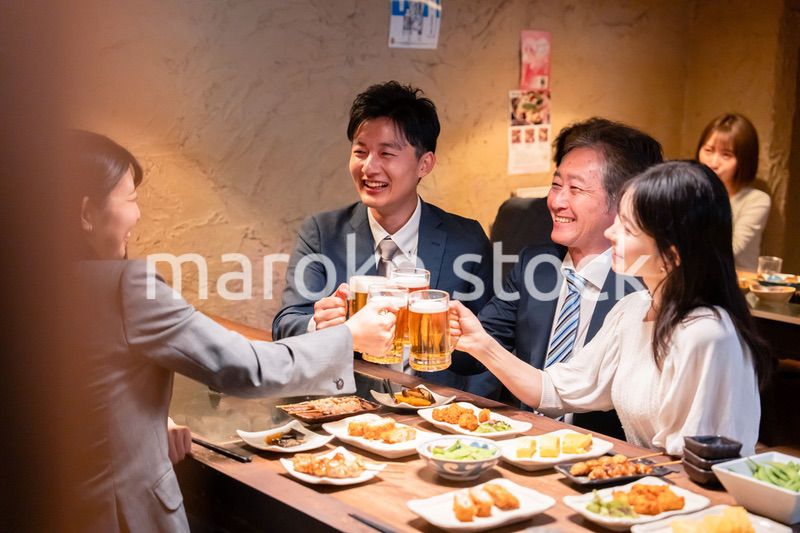 居酒屋で部署のお疲れ様会をするビジネスパーソン