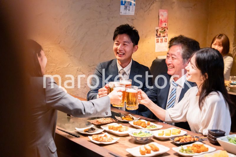 居酒屋で部署のお疲れ様会をするビジネスパーソン