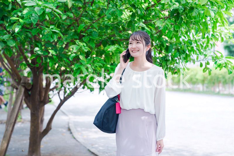 外で通話をする若い女性