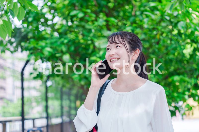 外で通話をする若い女性