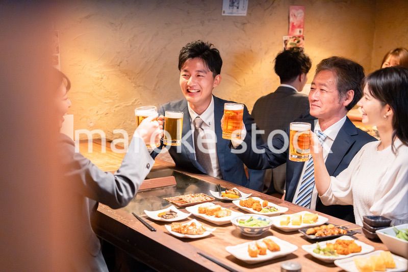 居酒屋で部署のお疲れ様会をするビジネスパーソン