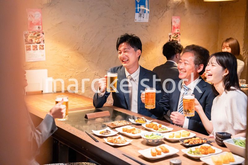 居酒屋で部署のお疲れ様会をするビジネスパーソン