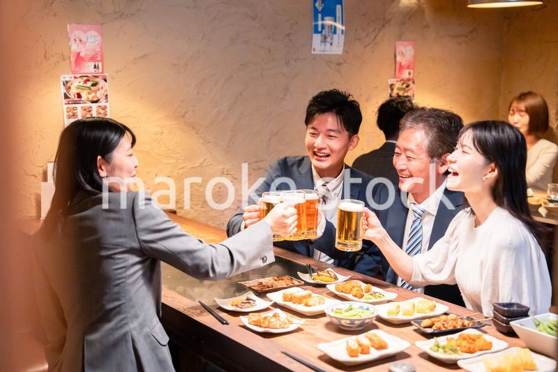居酒屋で部署のお疲れ様会をするビジネスパーソン