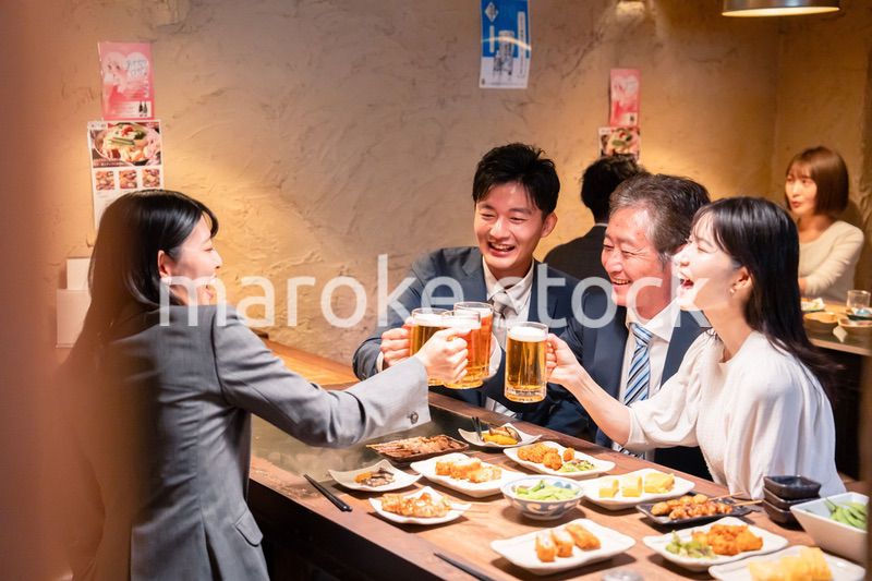 居酒屋で部署のお疲れ様会をするビジネスパーソン