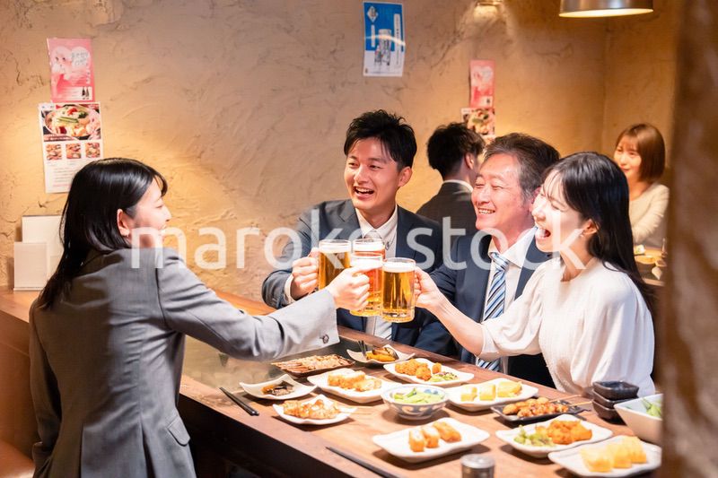居酒屋で部署のお疲れ様会をするビジネスパーソン