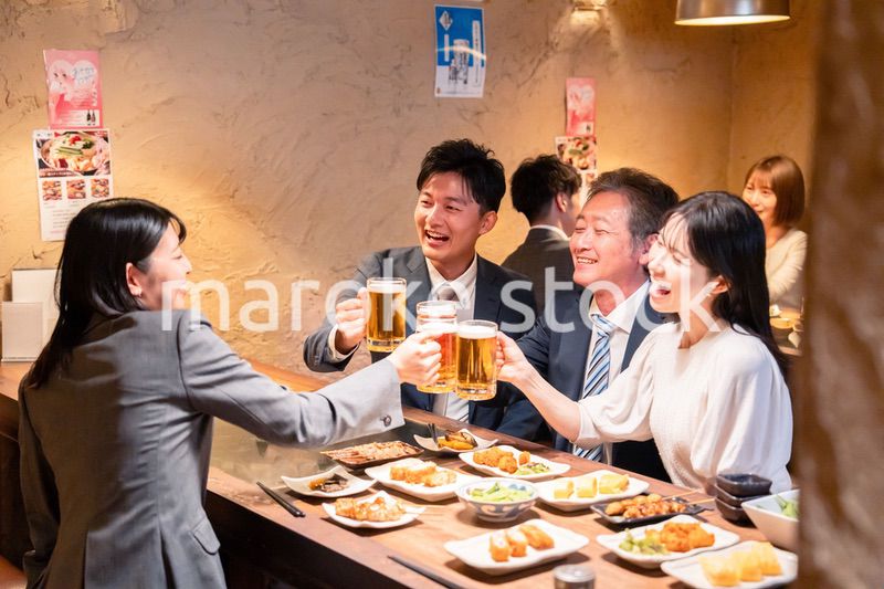 居酒屋で部署のお疲れ様会をするビジネスパーソン