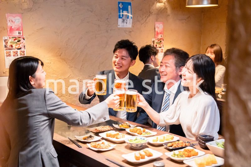 居酒屋で部署のお疲れ様会をするビジネスパーソン